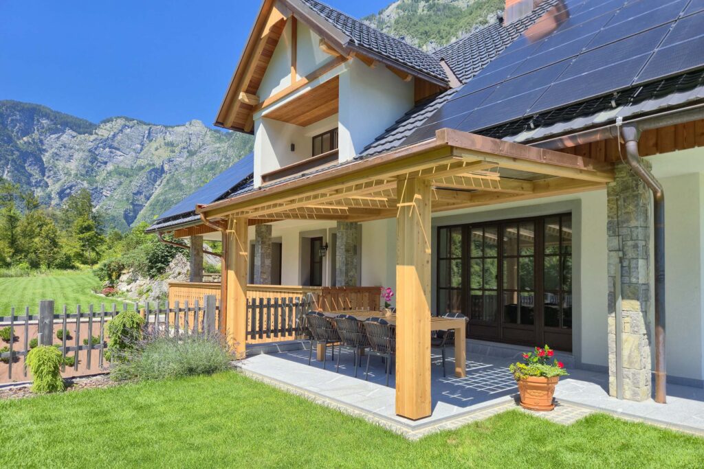 Luxury alpine Villa with covered terrace at Privillage Stare – B&B, Villa and Chalet Resort, surrounded by lush garden and mountain views near Lake Bohinj in Triglav National Park.