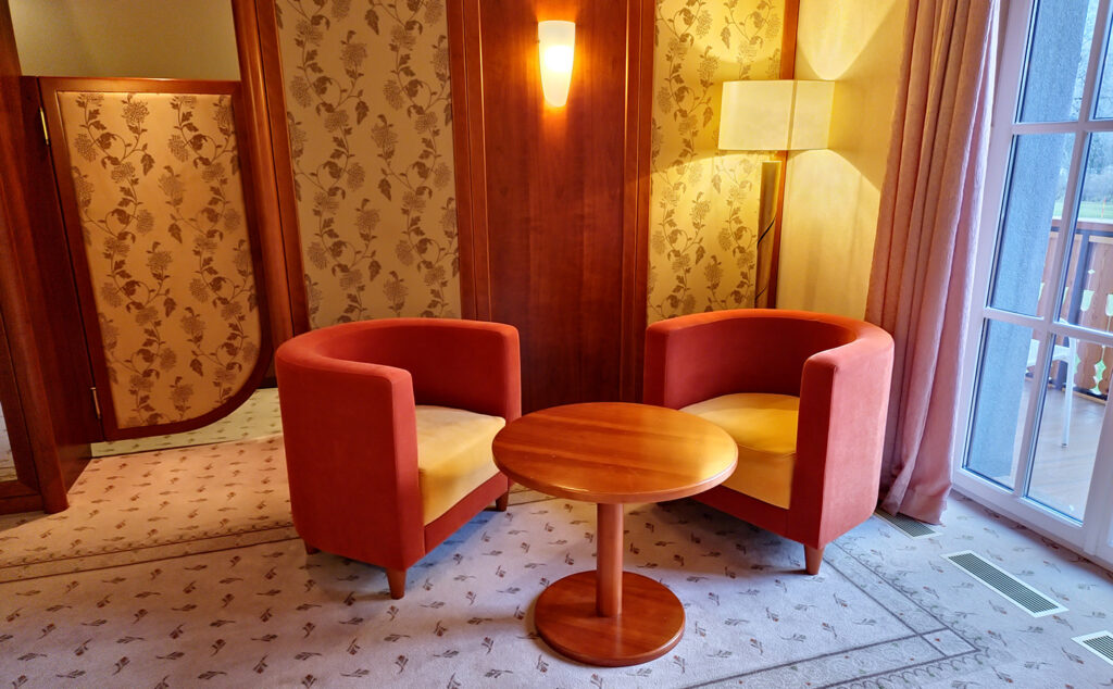 Luxury Alpine Villa lounge area with armchairs, wooden details and balcony access at Privillage Stare – B&B, Villa and Chalet Resort near Lake Bohinj.