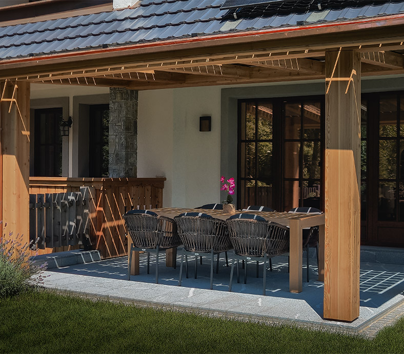 Covered terrace of the Luxury Alpine Villa in Bohinj with outdoor seating and dining area.