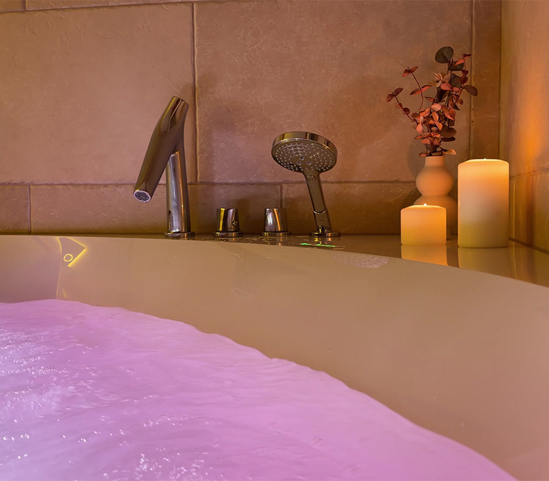 Relaxing private wellness bath with chromotherapy lighting and candles at Privillage Stare Alpine SPA Chalets in Bohinj.